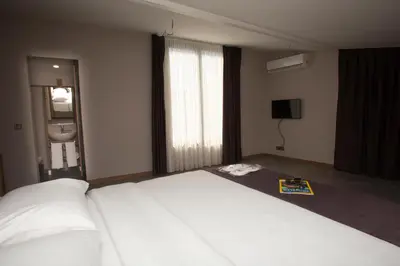 a bedroom with a large white bed and a television at Jurnal Hotel in Istanbul