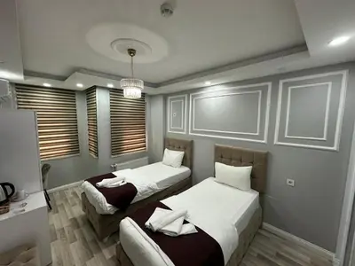 a bedroom with two beds and a desk at Modena Hotel in Istanbul
