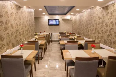 a restaurant with tables and chairs and a tv on the wall at Hotel Bestur in Istanbul