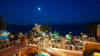 a crowd of people sitting around a patio at night at Seven Hills Palace & Spa in Istanbul