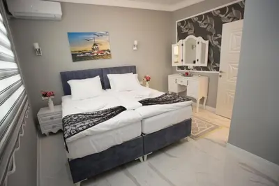 a bedroom with a large bed with a blue headboard at Little Palace Blue Apartment in Istanbul