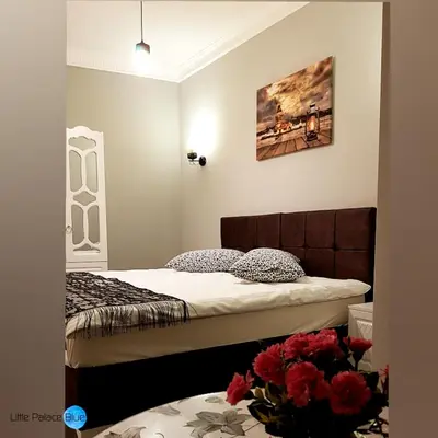 a bedroom with two beds and a vase of flowers at Little Palace Blue Apartment in Istanbul