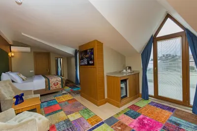 a attic bedroom with a bed and a window at Obelisk Hotel & Suites in Istanbul