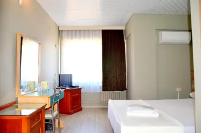 a hotel room with a bed and a desk and a window at Elite Hotel City Center Saray Bed and Breakfast in Saray