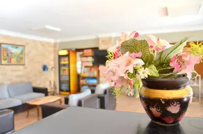 a vase filled with pink flowers sitting on a table at Elite Hotel City Center Saray Bed and Breakfast in Saray