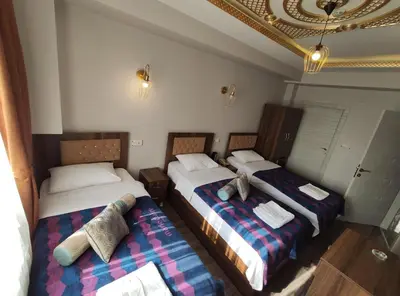 a room with two beds and a chandelier at DELBAB HOTEL in Istanbul