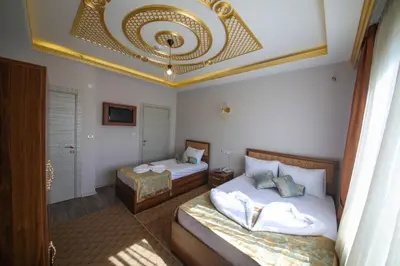 a bedroom with two beds and a chandelier at DELBAB HOTEL in Istanbul