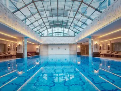 a large indoor swimming pool with a glass ceiling at CVK Park Bosphorus Hotel Istanbul in Istanbul