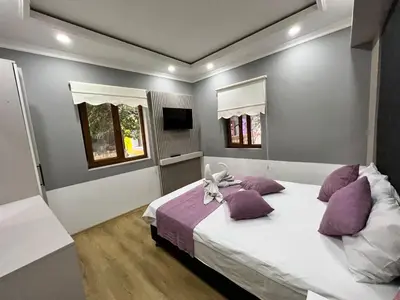 a bedroom with a large white bed with purple pillows at The Zanadu İstanbul in Istanbul