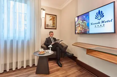 a man sitting in a room reading a book at Konak Hotel Taksim in Istanbul