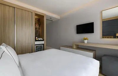 a bedroom with a white bed and a flat screen tv at Gleam Bomonti Hotel in Istanbul