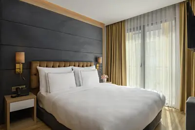 a bedroom with a large bed and a large window at Gleam Bomonti Hotel in Istanbul