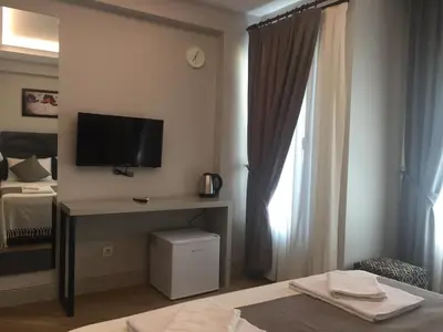a hotel room with a bed and a television on a wall at KONAK BELLA 3 in Istanbul