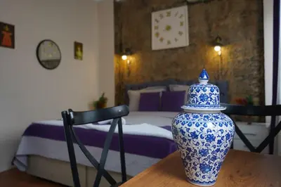 a blue and white vase sitting on a table with a bedroom at Medellin Apart Hotel Istanbul in Istanbul