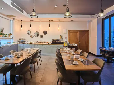 a restaurant with wooden tables and chairs and a kitchen at Four-G Hotel in Istanbul