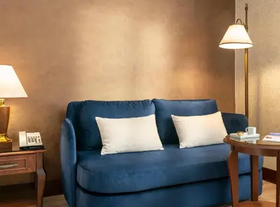 a blue couch with two white pillows in a room at Occidental Taksim in Istanbul