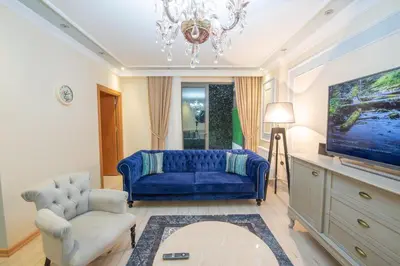 a living room with a blue couch and a tv at Three bedroom Duplex apartment with large terrace in Istanbul