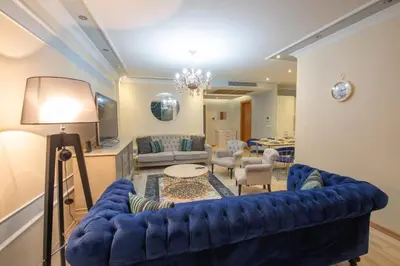 a living room with a blue couch and a table at Three bedroom Duplex apartment with large terrace in Istanbul