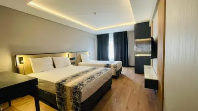 a hotel room with two beds and a window at Osmanbey Fatih Hotel in Istanbul