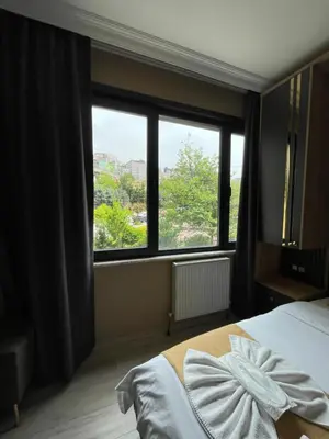 a bedroom with a bed and a large window at New Taksim Hotel in Istanbul