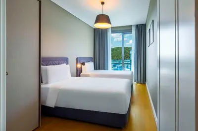 a hotel room with two beds and a window at Radisson Residences Vadistanbul in Istanbul