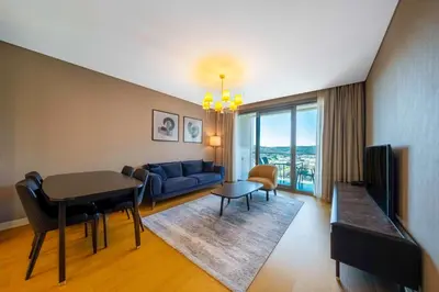 a living room with a blue couch and a table at Radisson Residences Vadistanbul in Istanbul