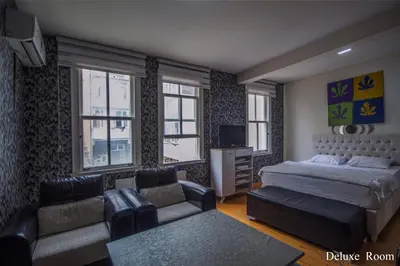 a bedroom with a bed and a couch and windows at PUHU OTEL in Istanbul