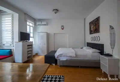 a bedroom with a bed and a dresser and a television at PUHU OTEL in Istanbul
