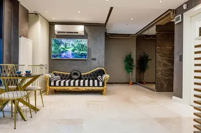 a living room with a couch and a tv on the wall at Norah Suites Hotel İstanbul in Istanbul