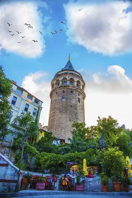 a building with a tower with birds in the sky at Norah Suites Hotel İstanbul in Istanbul