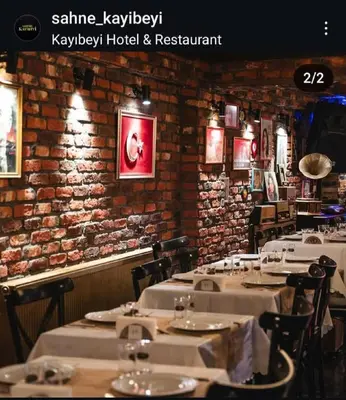 a row of tables in a restaurant with a brick wall at Kayıbeyi Hotel & Restaurant in Bursa