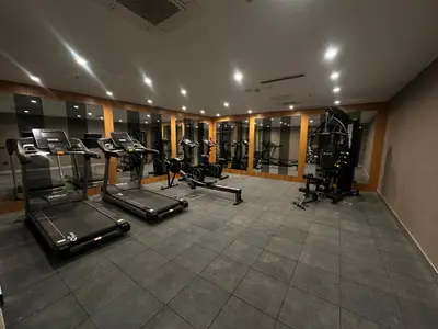 a gym with several treadmills and elliptical machines at Maywood Hotel in Istanbul