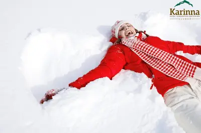 a young girl laying in the snow at Karinna Hotel Convention Center & Spa Luxury - Full Board Plus in Uludag