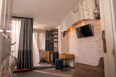 a living room with a tv on a brick wall at Corner Hot in Istanbul