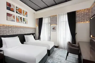 a hotel room with two beds and a desk at DeCamondo Galata, a Tribute Portfolio Hotel in Istanbul