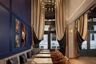 a long table in a room with curtains and chairs at DeCamondo Galata, a Tribute Portfolio Hotel in Istanbul