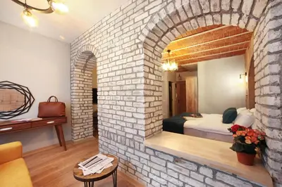 a room with a brick wall with a bed in it at Ardilas Residence in Istanbul