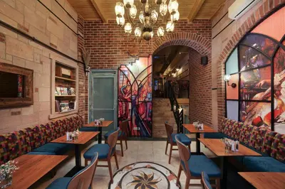 a restaurant with tables and chairs and a chandelier at Ardilas Residence in Istanbul