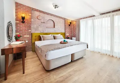 a bedroom with a large bed and a brick wall at Ardilas Residence in Istanbul
