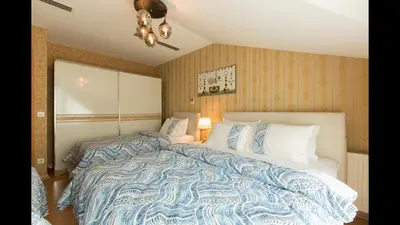 a bedroom with a large bed with a blue and white comforter at CTS Elysium Residence Duplex Apt. 85 in Istanbul