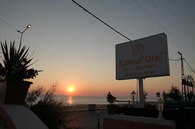 a sign for a restaurant on the beach at sunset at istanbul Airport Kumsal Otel in Arnavutköy