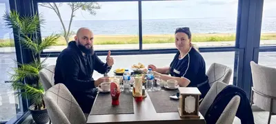 a man and woman sitting at a table in a restaurant at istanbul Airport Kumsal Otel in Arnavutköy