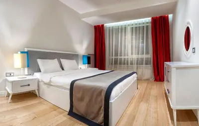 a bedroom with a large bed with red curtains at Armoni Residence & Hotel in Istanbul