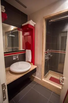 a bathroom with a white sink and a shower at Armoni Residence & Hotel in Istanbul