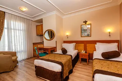 a hotel room with two beds and a living room at Santa Ottoman Hotel in Istanbul