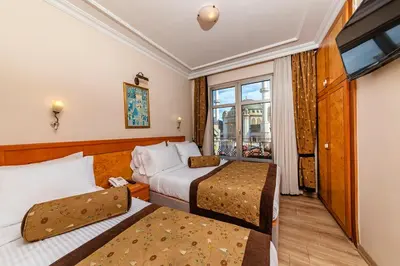 a hotel room with two beds and a window at Santa Ottoman Hotel in Istanbul