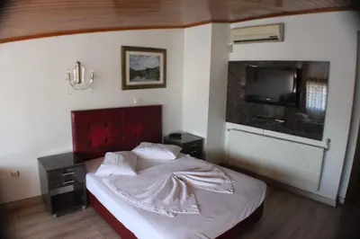 a bedroom with a bed with a red headboard and a tv at Kosk Hotel Kadikoy in Istanbul