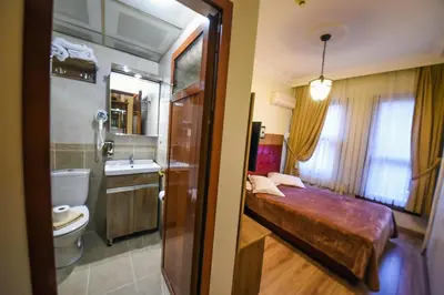 a bathroom with a bed and a toilet and a sink at Kosk Hotel Kadikoy in Istanbul