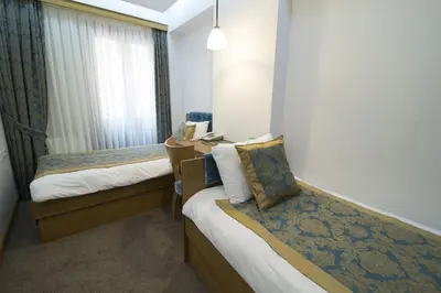 a hotel room with two beds and a desk at Cumbali Suite Hotel in Istanbul