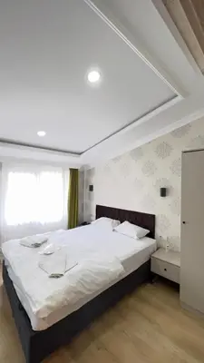 a bedroom with a large white bed and a window at The Lola Hotel in Istanbul